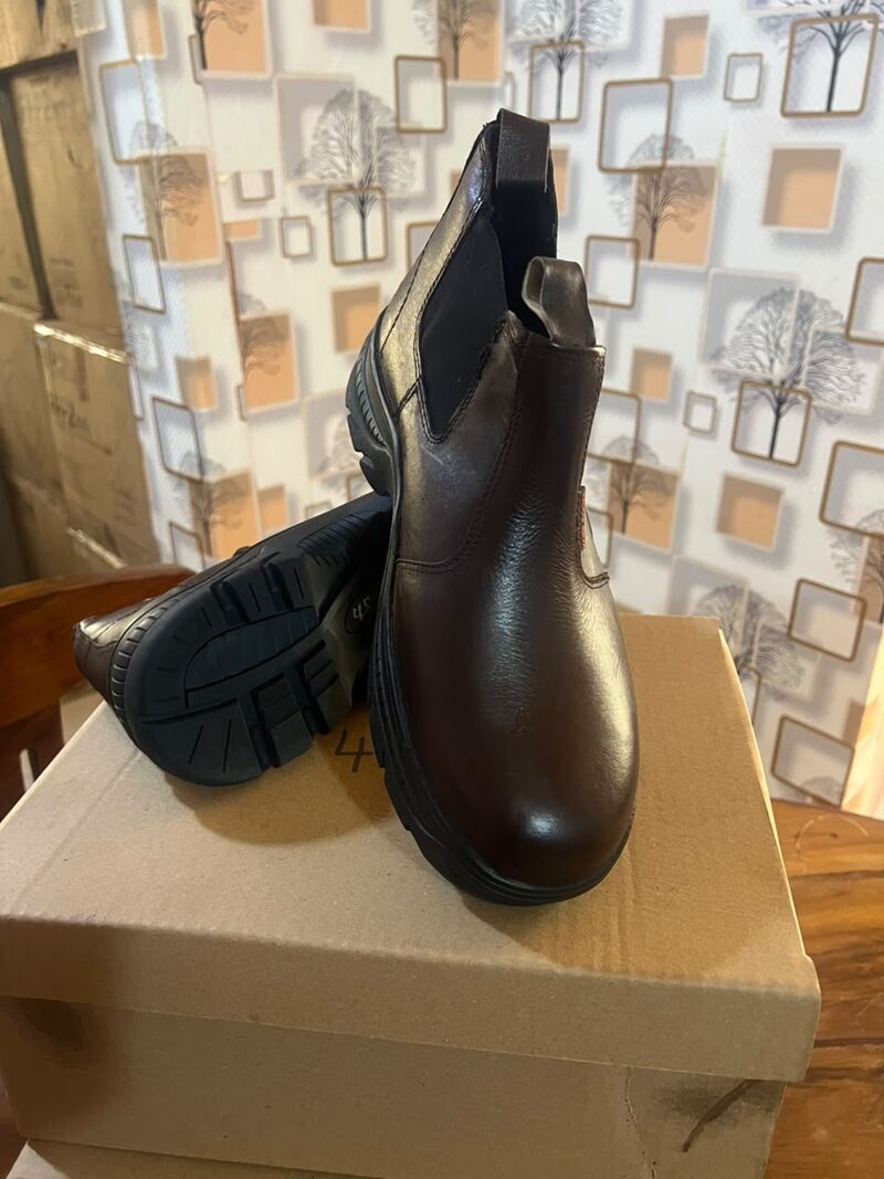 Brown Chelsea boots with one sole visible